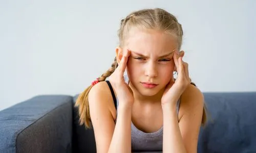 Jeune fille qui se tient les tempes