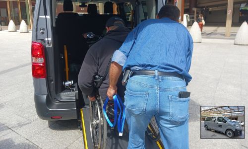 Personne en fauteuil montant à l’arrière de la navette via un plan incliné.