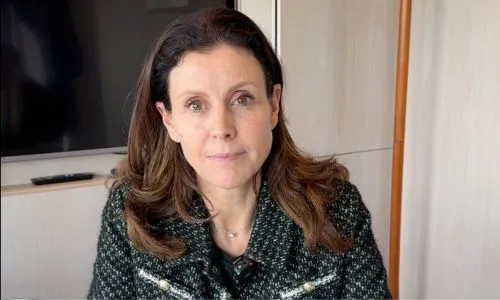 Charlotte Parmentier-Lecocq souriante, assise &agrave; un bureau.