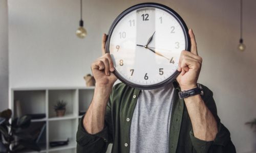 Horloge cachant le visage d’un homme dans un bureau