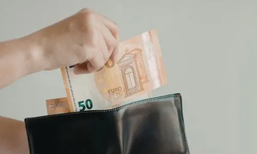 Quelqu&rsquo;un sui met un billet de 50 euros dans un porte-feuille