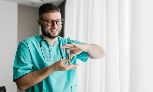 un m&eacute;decin qui communique en langue des signes