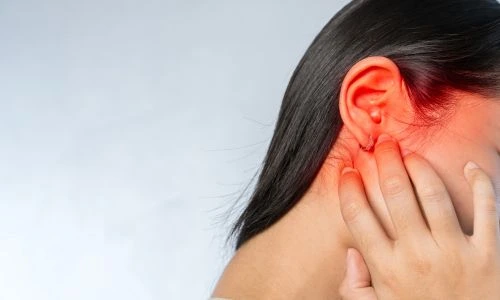 Une jeune femme se tient l&rsquo;oreille rougie