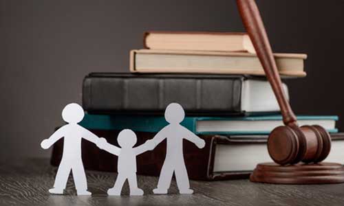 Figurines d’une famille en papier devant le marteau de la justice