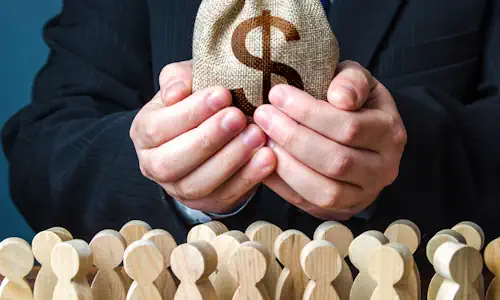 Personne tenant un sac d'argent au dessus de figurines