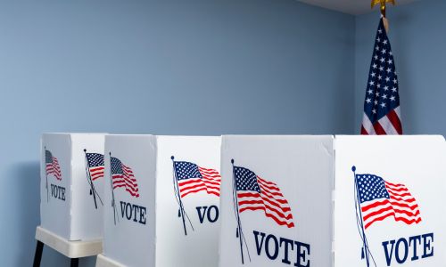 3 urnes où sont mis les bulletins de vote avec un drapeau américain.