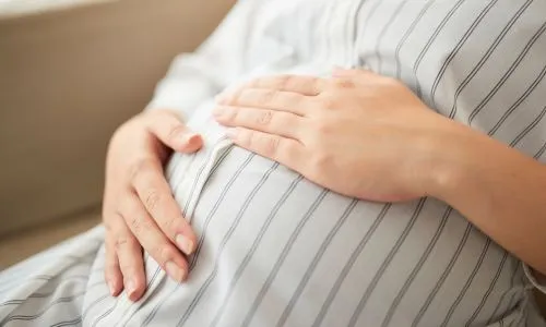 Femme enceinte qui se tient le ventre.