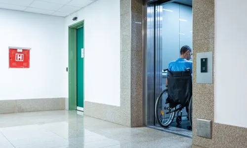 Homme en fauteuil roulant dans un ascenseur