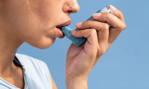 Femme utilisant son inhalateur pendant une crise d'asthme
