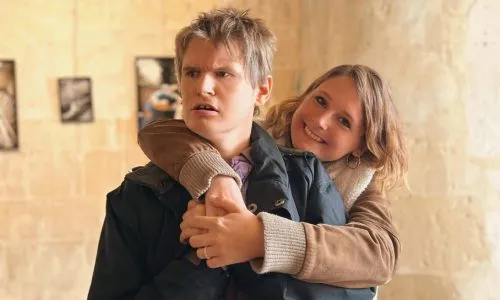 Lucie prend son frère Antoine dans les bras.