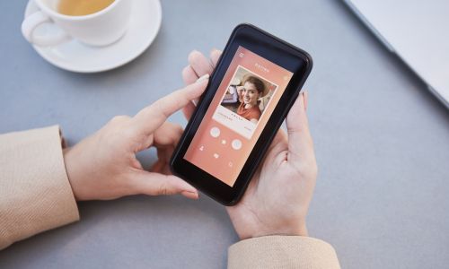 Une personne pianotant sur une appli de rencontres dans un café.