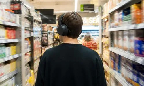 Jeune homme avec un casque anti-bruit sur les oreilles dans un magasin