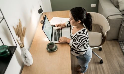Une femme de petite taille &agrave; son domicile, sur son ordinateur.