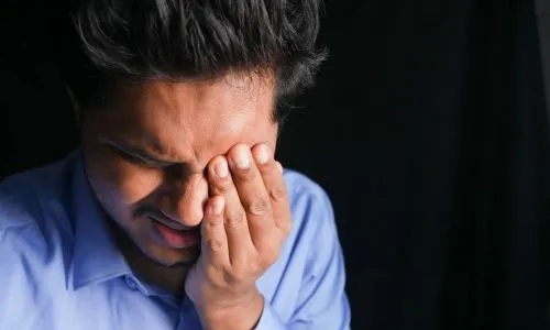 un homme se tient l'&oelig;il gauche &agrave; cause de douleurs