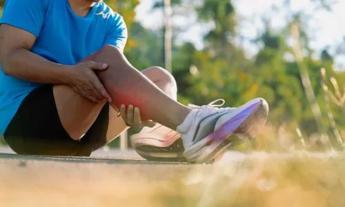 Un sportif se tient le mollet apr&egrave;s une s&eacute;ance de sport