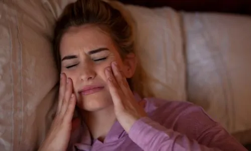 Jeune femme qui se tient les joues