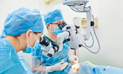 Chirurgiens qui op&egrave;rent un patient au niveau des yeux