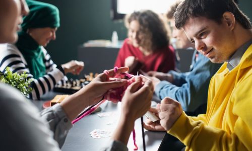 Un enfant avec trisomie joue aux cartes dans un centre de loisirs.