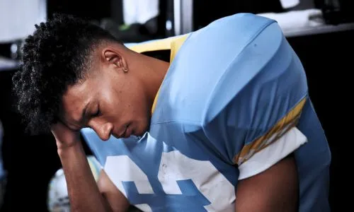 joueur de football am&eacute;ricain se tenant la t&ecirc;te