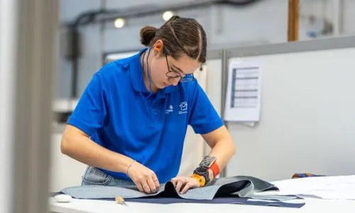 Une compétitrice handicapée en train de coudre sur l’atelier mode/création.