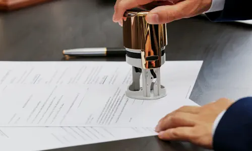 Une main tamponnant un document