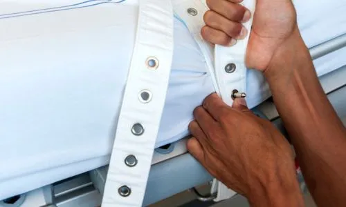 infirmier qui contentionne avec une sangle