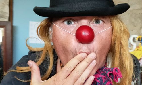 Fabrice Bertin, déguisé en clown, qui met la main devant sa bouche.