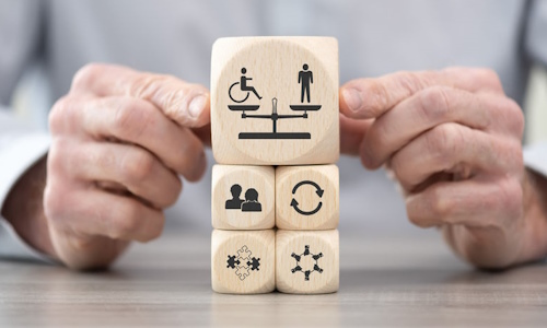 Construction de cubes en bois avec des motifs évoquant le handicap