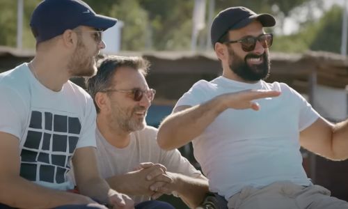 Michaël Jérémiasz, Frédéric Lopez & l’un des participants discutent sur la plage