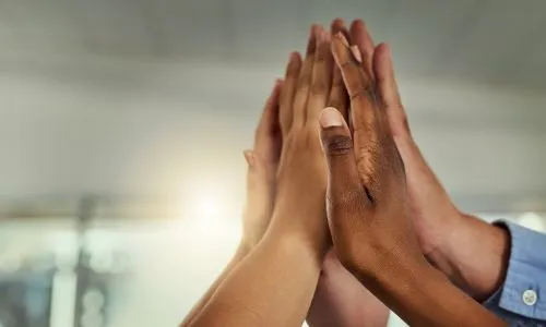 Plusieurs personnes joignent leurs mains en signe de solidarité.