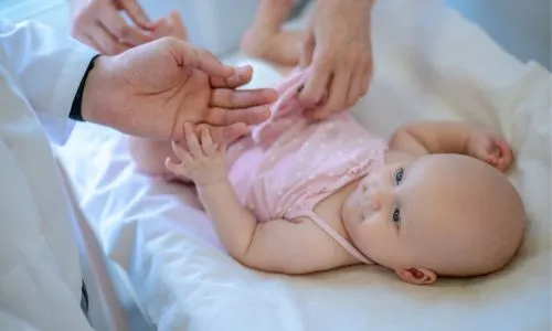 Chirurgien examinant les jambes du b&eacute;b&eacute; pour d&eacute;tecter une dysplasie