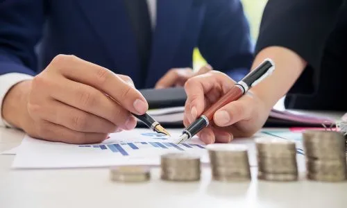 Zoom sur des graphiques et des piles de pièces de monnaie.