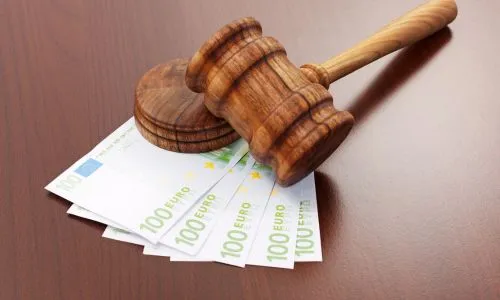 Un marteau de la justice en bois posé sur une liasse de billets (euros).