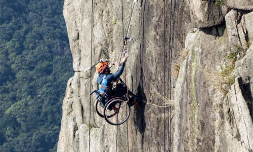 Illustration article Il escalade une montagne en fauteuil roulant