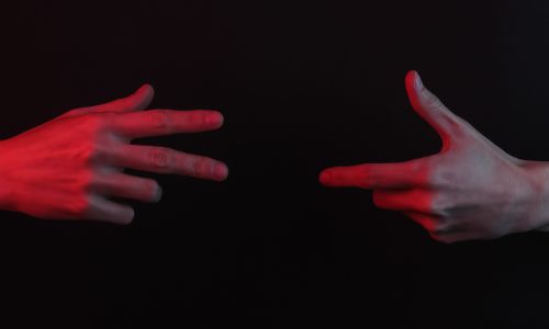 Deux mains, dans le noir, en train de signer.