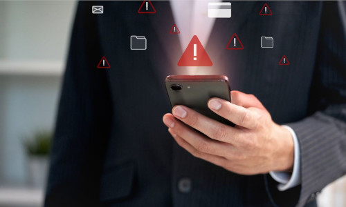 personne avec son t&eacute;l&eacute;phone qui re&ccedil;oit des messages avec symbole attention