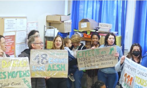 Des parents manifestent avec des pancartes pour une école plus inclusive.