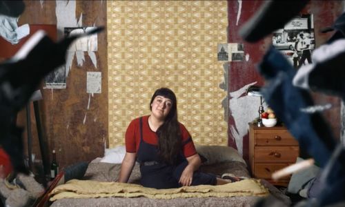 Ellice sur son lit, entourée de vêtements et autres affaires qui tombent du ciel