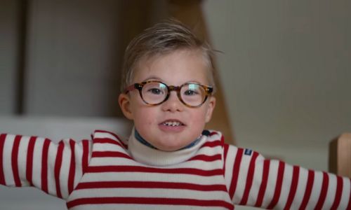 Portrait de Victor, porteur de trisomie 21, ouvrant grand les brans.