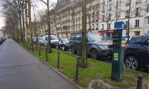 2 SUV garés devant un horodateur dans une rue de Paris.