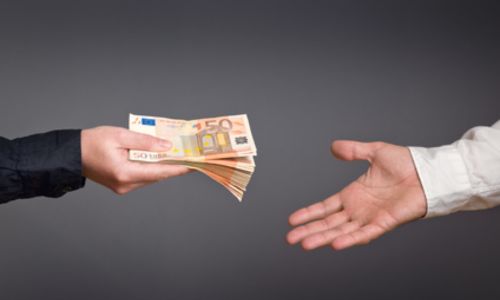 Un homme donne une liasse de billets à un autre.