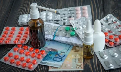 Des médicaments posés sur des billets (euros).