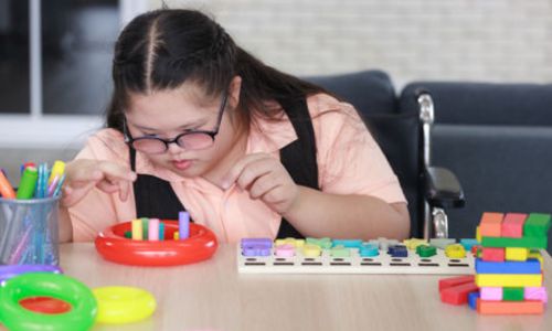 Une jeune fille trisomique en train de compter dans sa classe.