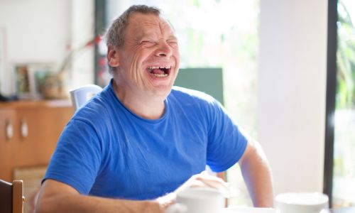 Une personne âgée handicapée qui rit aux éclats