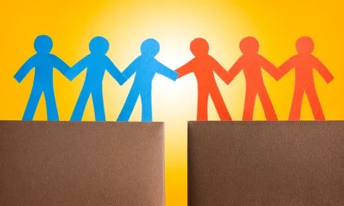 Des figurines se tiennent la main mais sont séparées par un écart.