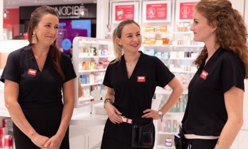 3 conseillères beauté en magasin, souriante.