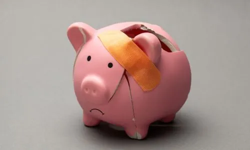 Tirelire cochon cass&eacute;e et triste, avec un pansement.