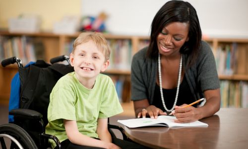 Une AESH apporte une aide individualis&eacute;e &agrave; un &eacute;l&egrave;ve en classe