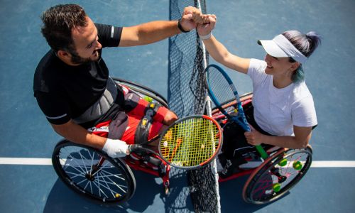 Deux pratiquants de para tennis se saluent avec le poing.