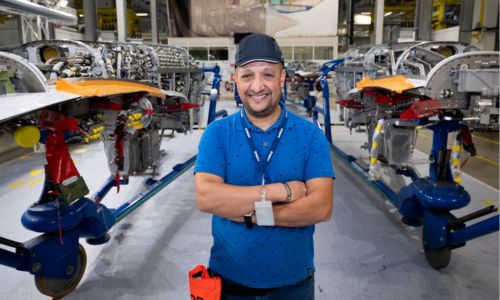 Un salarié handicapé souriant, travaillant dans le secteur de l’aéronautique.